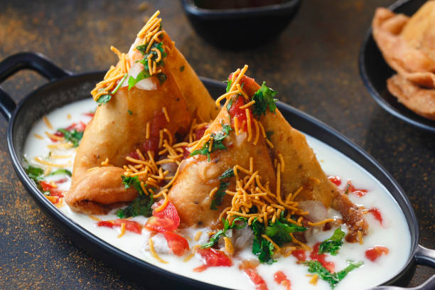 Curd Samosa Chaat, Indian vegetarian snacks served with tamarind chutneys. Curd Samosa Chaat, Indian vegetarian snacks served with tamarind chutneys.